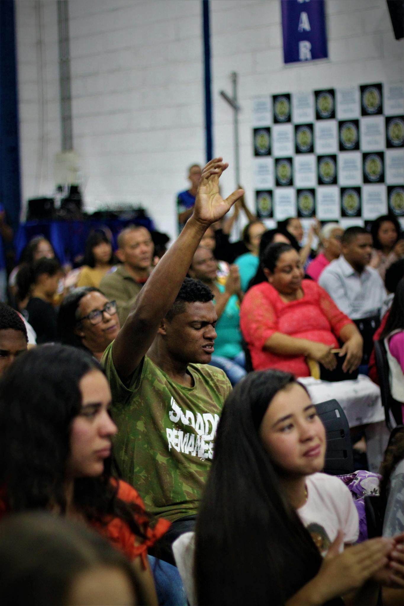 A diverse gathering of people engaged in a worship service, showing expressions of devotion and faith.