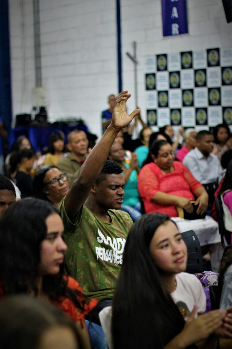 A diverse gathering of people engaged in a worship service, showing expressions of devotion and faith.